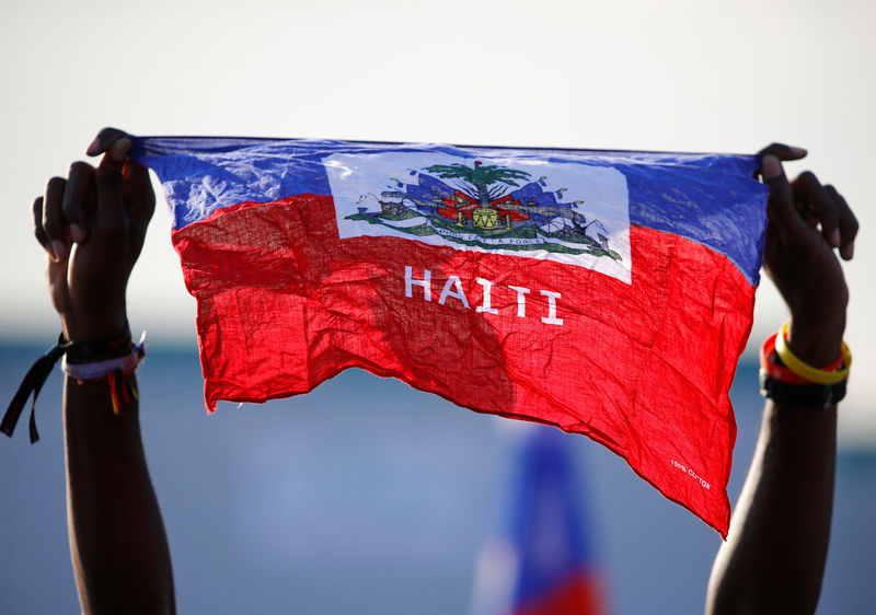 © Reuters. uA girl holds national flag of Haiti before Pope Francis' arrival at the Campus Misericordiae during World Youth Day in Brzegi, near Krakow