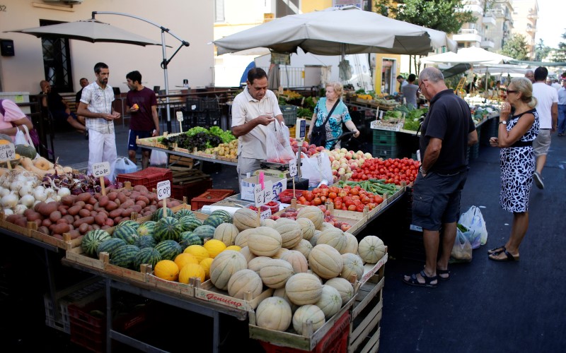 © Reuters. People buy fruit and vegetables in a street market in Rome