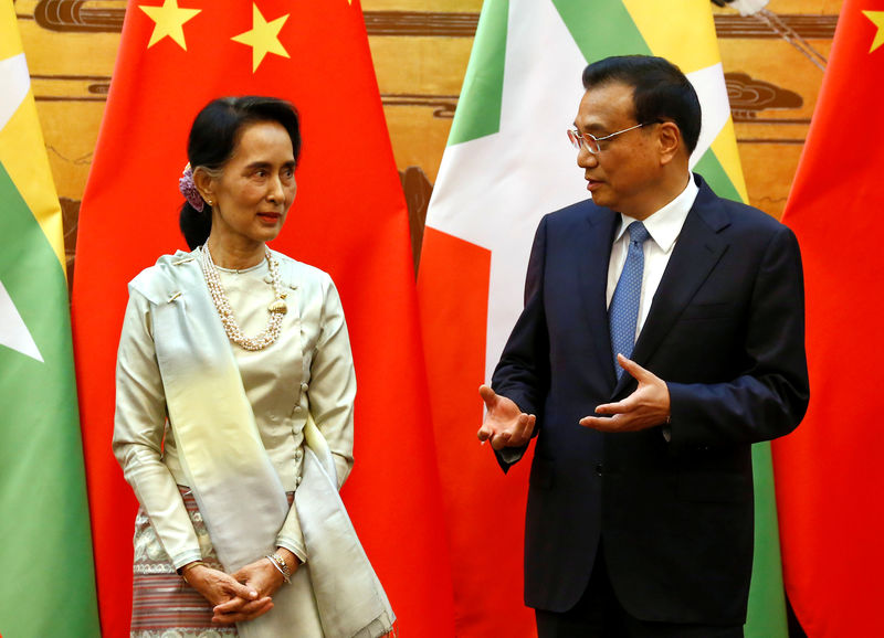 © Reuters. Myanmar State Counsellor Aung San Suu Kyi (L) and Chinese Premier Li Keqiang (R) talk during a signing of agreements ceremony in Beijing