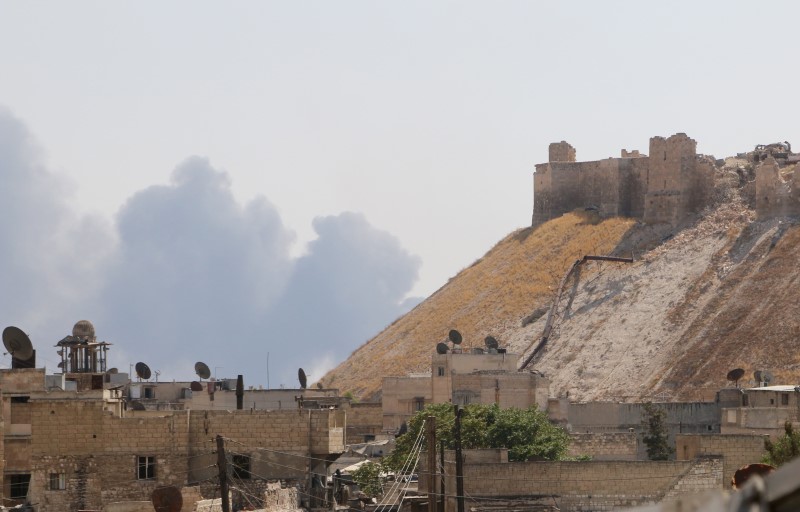 © Reuters. Smoke rises behind Aleppo's historic citadel, controlled by forces loyal to Syria's President Bashar al-Assad, as seen from a rebel-held area of Aleppo