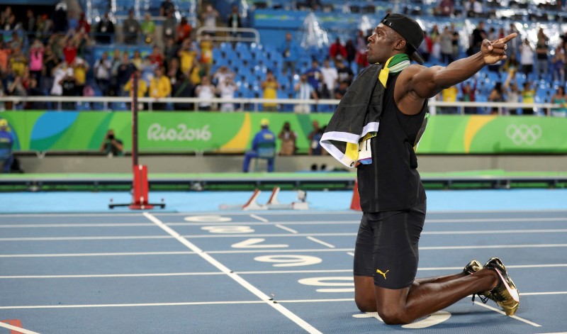 © Reuters. المنافسون يشيدون ببولت بعد سباقه الأولمبي الأخير