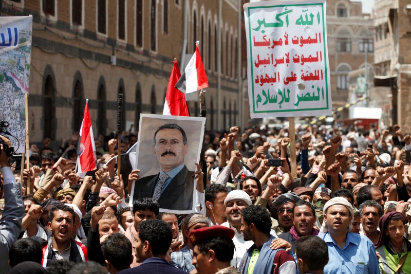 © Reuters. People hold a poster of Yemen's former president Ali Abdullah Saleh as they demonstrate outside a parliament a session in Sanaa, Yemen