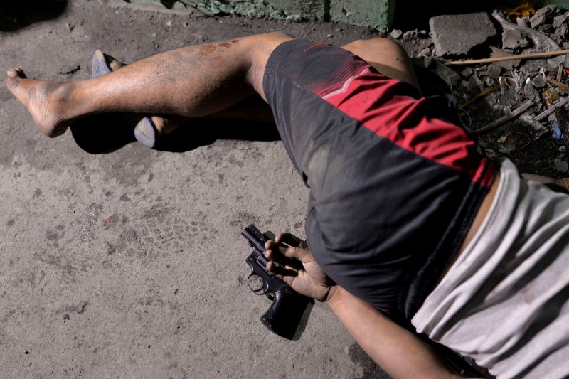 © Reuters. The body of a man is pictured with a gun under his hand, whom police said was killed during a drug bust operation on "Shabu" (Meth), in Manila