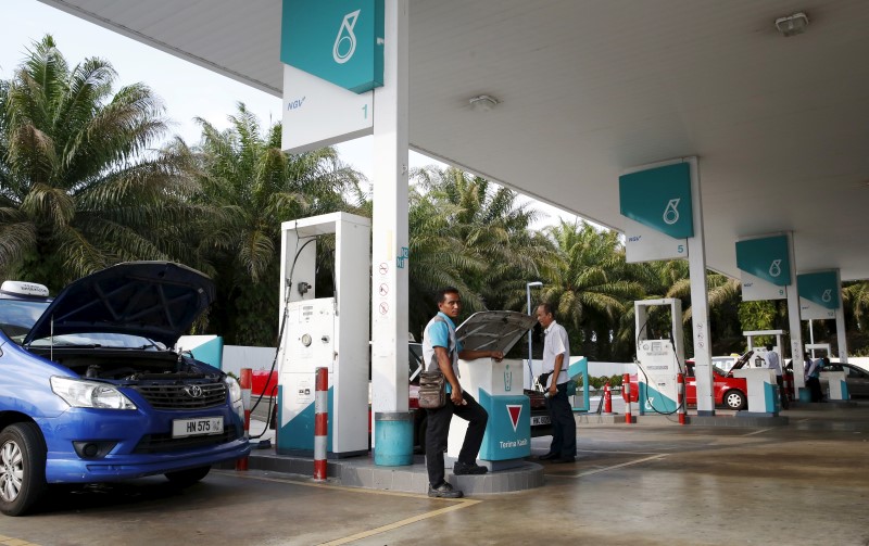© Reuters. A pump attendant works at a Petronas petrol station outside Kuala Lumpur, Malaysia