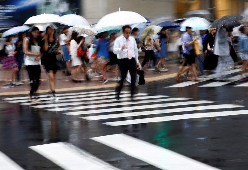 © Reuters. Pessoas vistas durante chuva em Tóquio