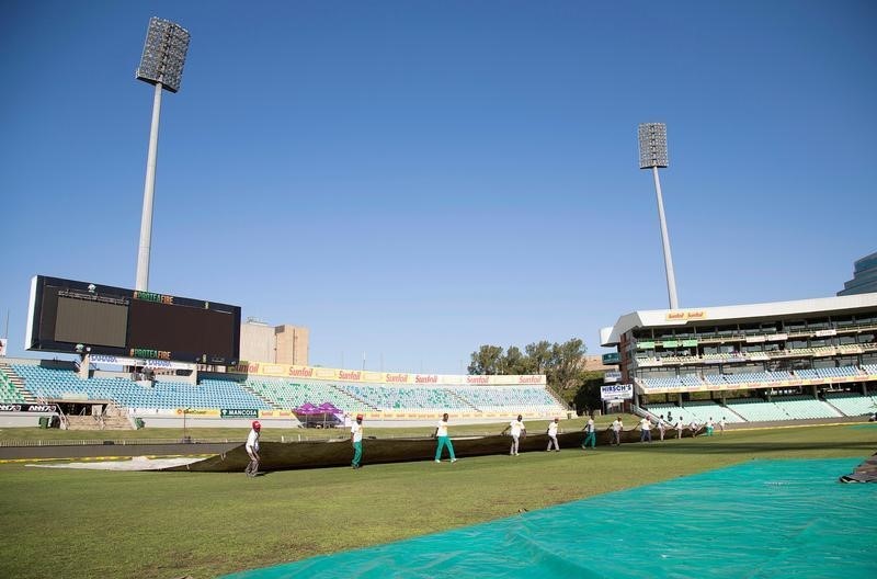 © Reuters. Ground staff cover the pitch after the play was abandoned due heavy overnight rain on the third day of the first cricket test match between South Africa and New Zealand in Durban