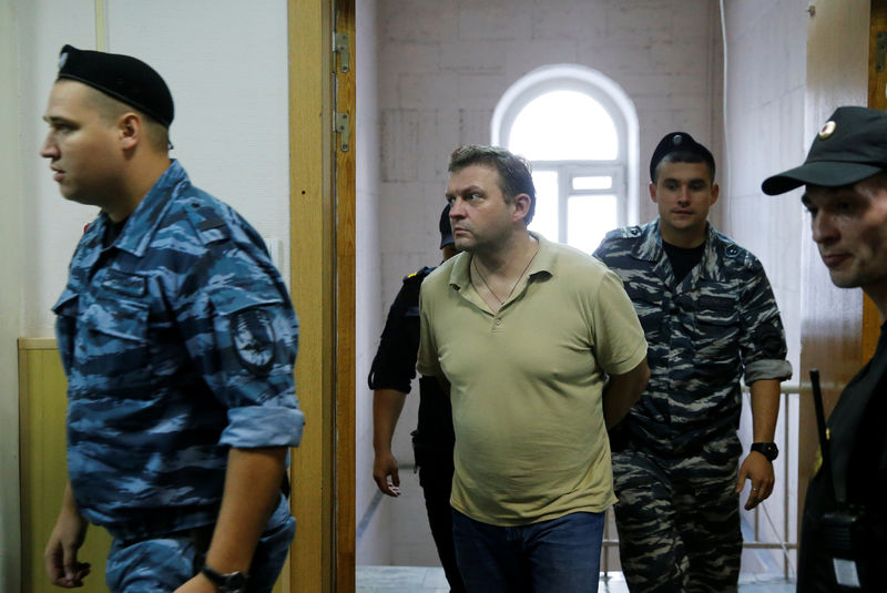 © Reuters. Former governor of Kirov region Belykh is escorted by police officers during hearing at Basmanny district court in Moscow