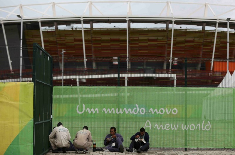 © Reuters. Workers have lunch outside the Olympic Park in Rio de Janeiro