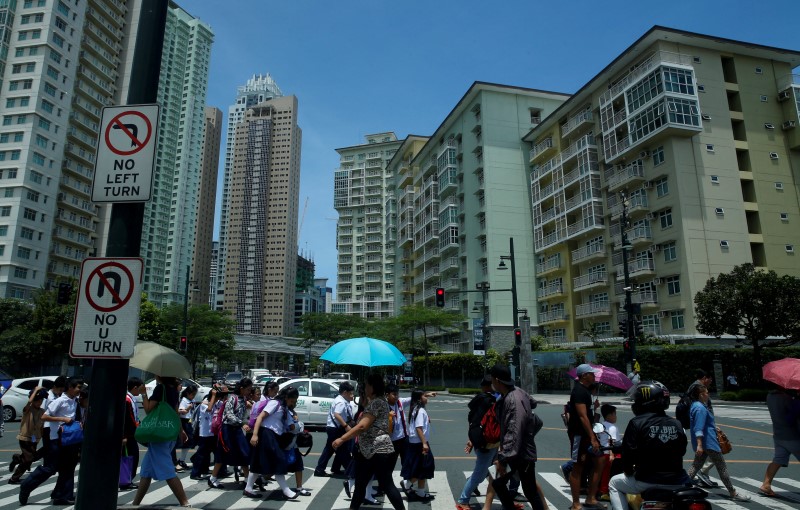 © Reuters. Residents walk along a pedestrian lane overlooking Serendra Condominium buildings in Bonifacio Global City in Taguig, Metro Manila