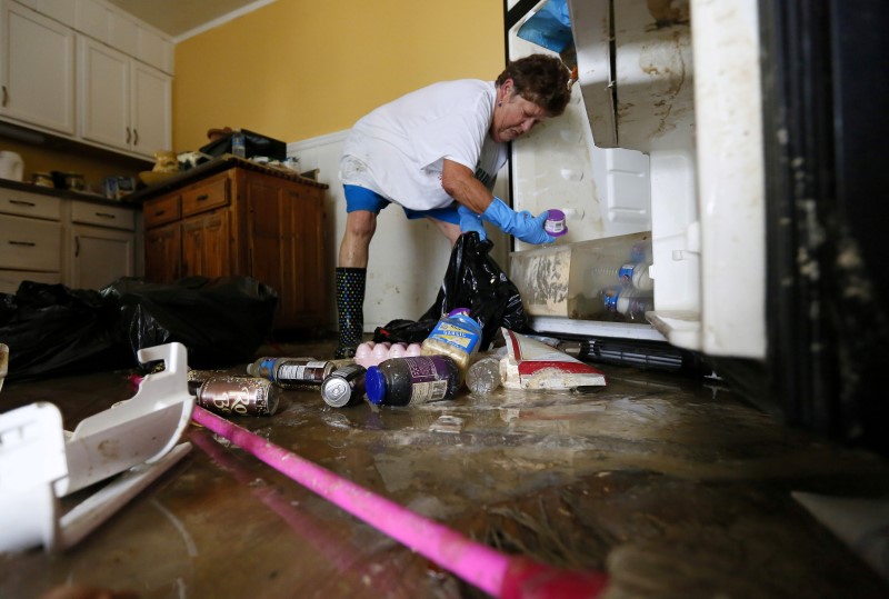 © Reuters. Samantha Labatut cleans out a refrigerator inside her flood damaged kitchen in St. Amant