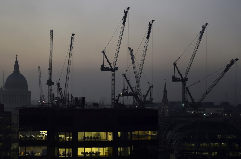 © Reuters. Offices are seen at dusk as St. Paul's cathedral and construction cranes are seen on the skyline in the City of London
