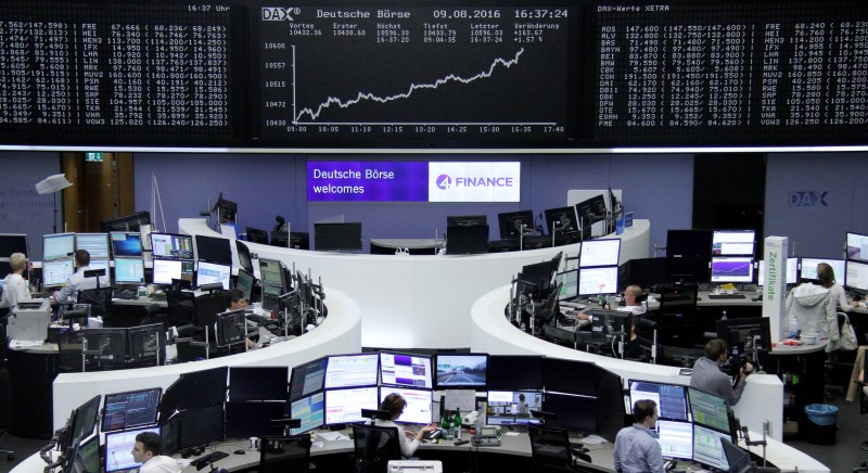 © Reuters. Traders work at their desks in front of the German share price index DAX board in Frankfurt