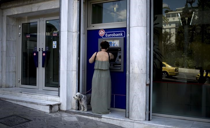 © Reuters. Woman uses a Eurobank ATM in Athens