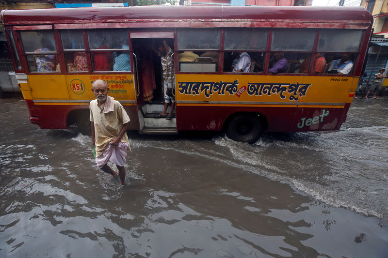 © Reuters. A man walks through a flooded street in Kolkata