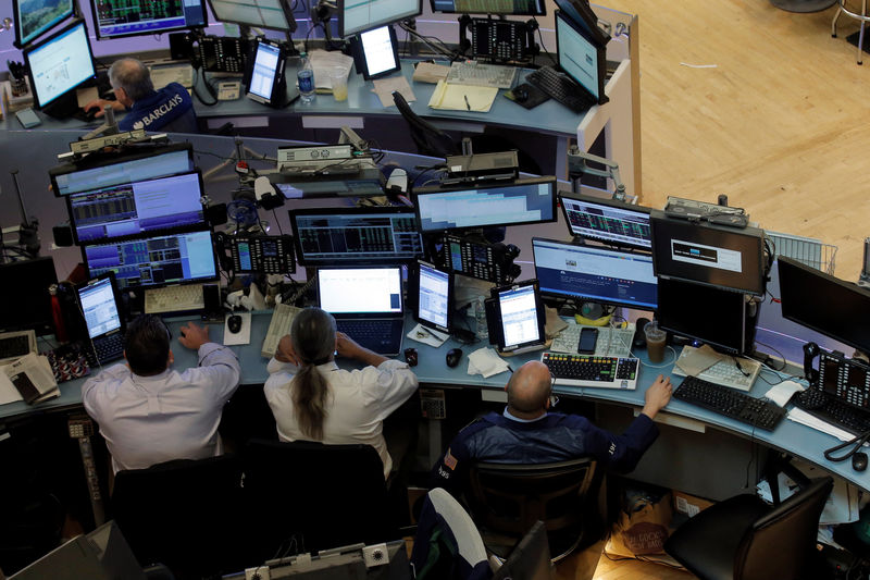 © Reuters. Traders work at desks on the floor of the NYSE