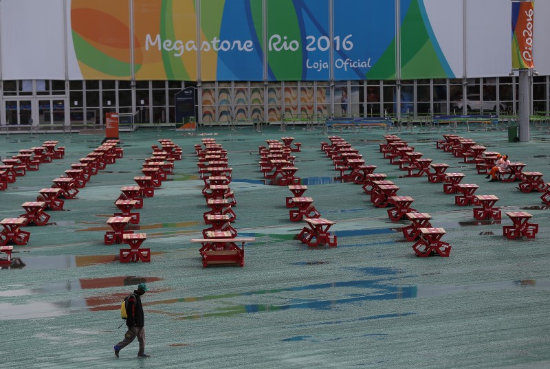 © Reuters. A person walks in the rain through the Olympic Park in Rio de Janeiro