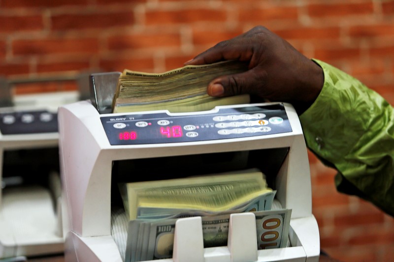 © Reuters. A bureau de change operator counts U.S. currency notes in Abuja