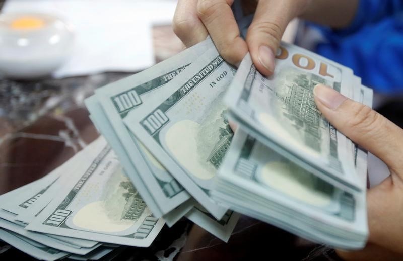 © Reuters. An employee of a bank counts US dollar notes at a branch in Hanoi