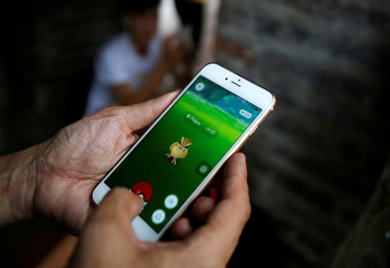 © Reuters. A man plays "Pokemon Go" by Hoan Kiem Lake in Hanoi