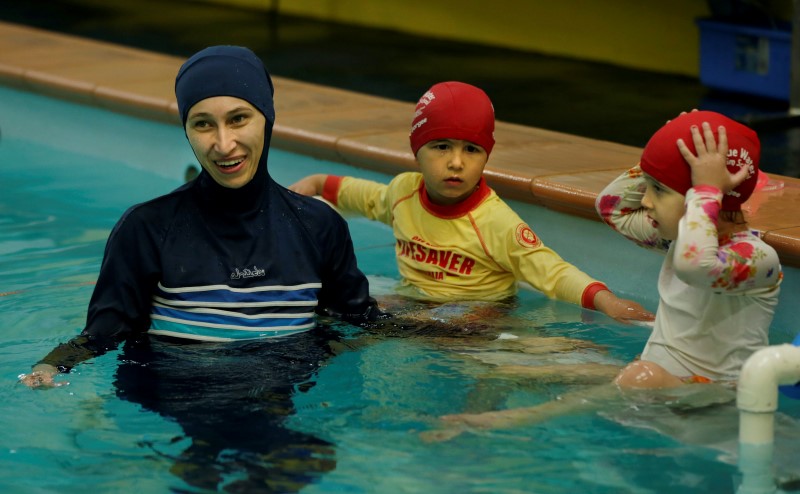 © Reuters. Australian muslim swimming instructor Fadila Chafic wears her full-length 'burkini' swimsuit during a swimming lesson with her children Taaleenand Ibrahim at swimming pool in Sydney