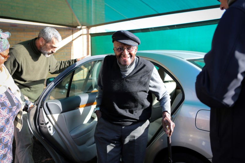 © Reuters. Archbishop Emeritus Desmond Tutu arrives to cast his vote during the local governement elections in Milnerton, Cape Town