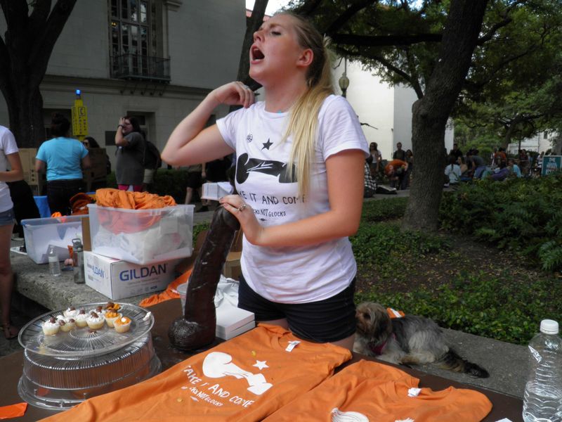 © Reuters. University of Texas student Rosie Zander holds a sex toy on her table at a protest against a state law that allows for guns in classrooms at college campuses, in Austin, Texas