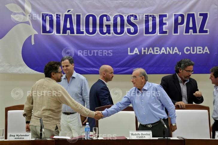 © Reuters. Colombia's lead government negotiator Humberto de la Calle and Colombia's FARC lead negotiator Ivan Marquez shake hands after signing the protocol and timetable for the disarmament of the FARC  in Havana