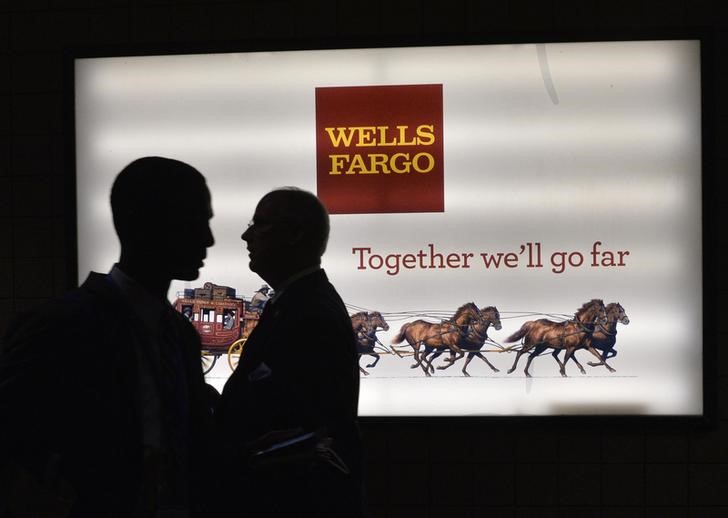 © Reuters. Men pass a sign at Wells Fargo Center at the Democratic National Convention in Philadelphia