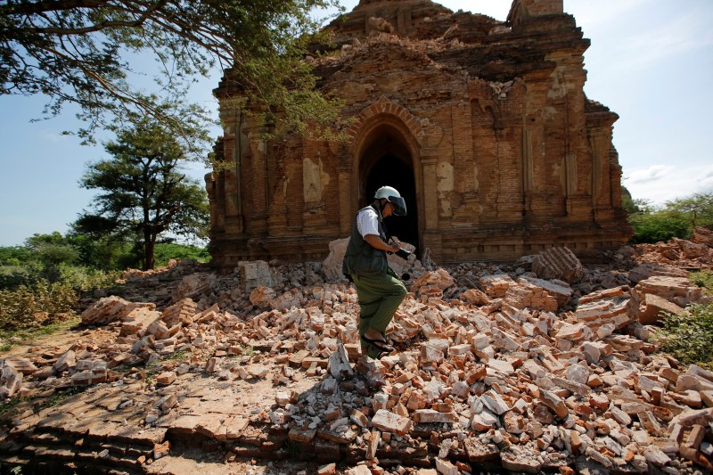 © Reuters. A photograper walks outside a collapsed pagoda after an earthquake in Bagan