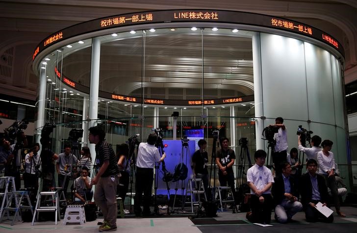 © Reuters. Members of the media wait for Line Corp's bell ceremony to mark the company's debut on the TSE in Tokyo