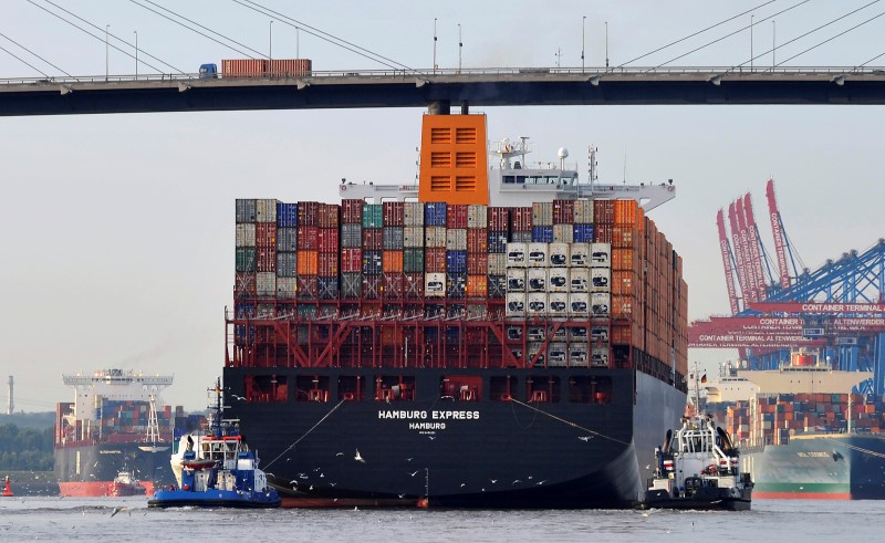 © Reuters. Towboats tow the container ship "Hamburg Express" as it passes below  the Koehlbrand bridge during its arrival near the Port of Hamburg