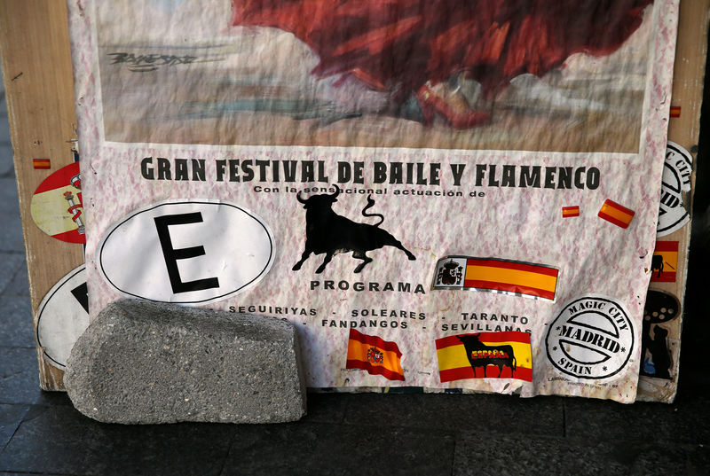 © Reuters. Stickers of Spanish flags and bulls can be seen on a banner in front of a souvenir shop in central Madrid, Spain