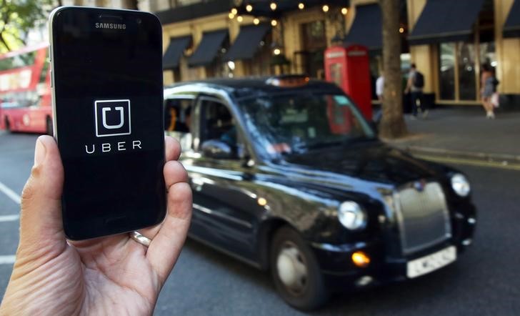 © Reuters. A photo illustration shows the Uber app logo displayed on a mobile telephone, as it is held up for a posed photograph in central London