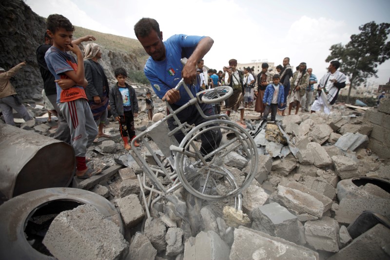 © Reuters. A man retrieves a wheelchair amidst the rubble of a house after it was destroyed by a Saudi-led air strike in Yemen's capital Sanaa