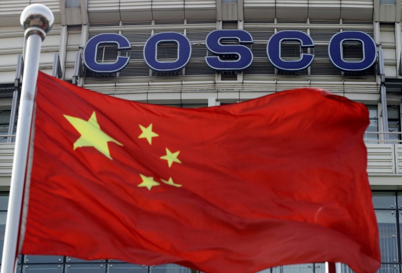 © Reuters. A Chinese national flag flies in front of COSCO's headquarters in Beijing