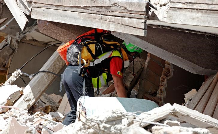 © Reuters. Agente faz buscas após terremoto em Amatrice