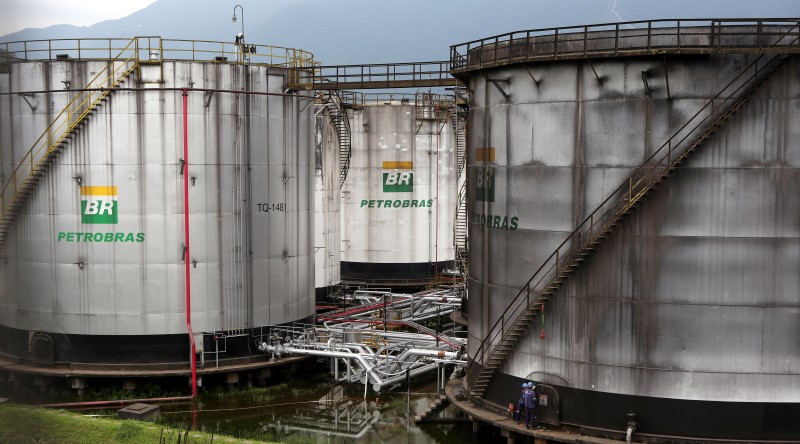 © Reuters. Workers repair a tank of Brazil's state-run Petrobras oil company in Cubatao