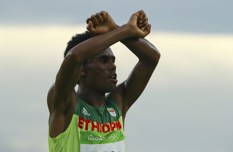 © Reuters. Feyisa Lilesa faz protesto durante a maratona no Rio