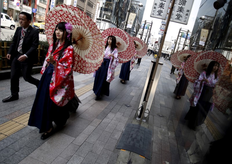 © Reuters. Women in Kimono holding an umbrella walk on a street at Ginza shopping district in Tokyo