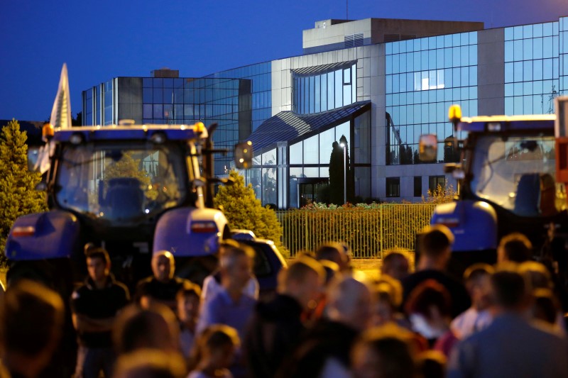 © Reuters. French dairy farmers from the FNSEA union block the round-about access to the Lactalis plant as they protest against the  price of milk in Laval