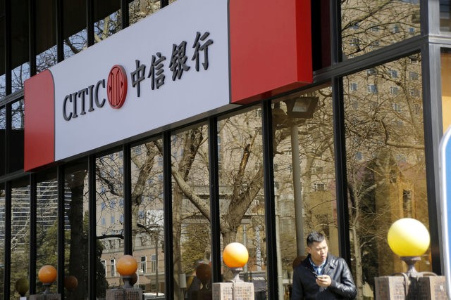 © Reuters. File photo of man standing in front of CITIC bank's branch in Beijing