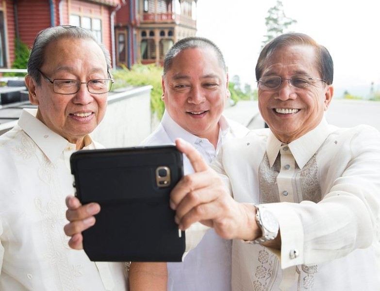 © Reuters. Exiled founder of the Communist Party Sison, government official Fornier and Philippines' presidential peace adviser Dureza take a selfie photo during peace talks between the Philippine government and the NDFP in Oslo