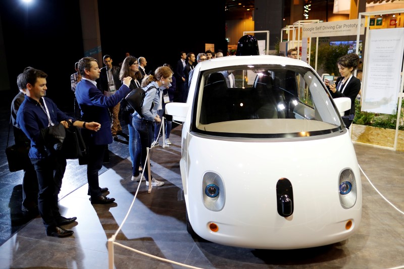 © Reuters. Visitors look at a self-driving car by Google displayed at the Viva Technology event in Paris
