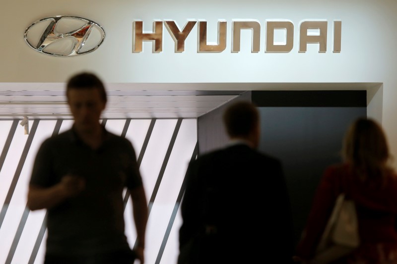 © Reuters. People walk past logo of Hyundai on car maker's booth at 2016 Moscow International Auto Salon in Moscow