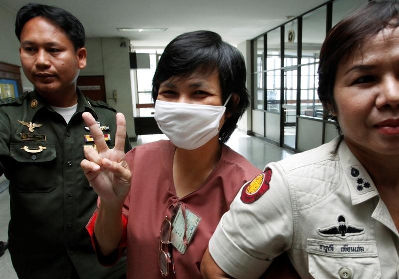 © Reuters. Darunee Charnchoengsilpakul, a supporter of ousted premier Thaksin Shinawatra, gestures after leaving a courtroom in Bangkok in this file photo