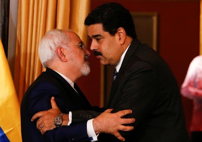 © Reuters. El presidente venezolano Nicolás Maduro (derecha) y el ministro de Asuntos Exteriores de Irán,  Mohammad Javad Zarif, se abrazan durante una reunión en Caracas