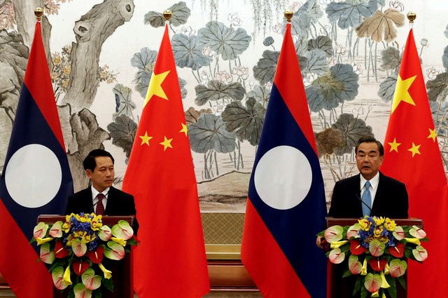 © Reuters. Laos' Foreign Minister Saleumxay Kommasith (L) and his Chinese counterpart Wang Yi hold a news conference after a meeting at the Diaoyutai State Guesthouse in Beijing
