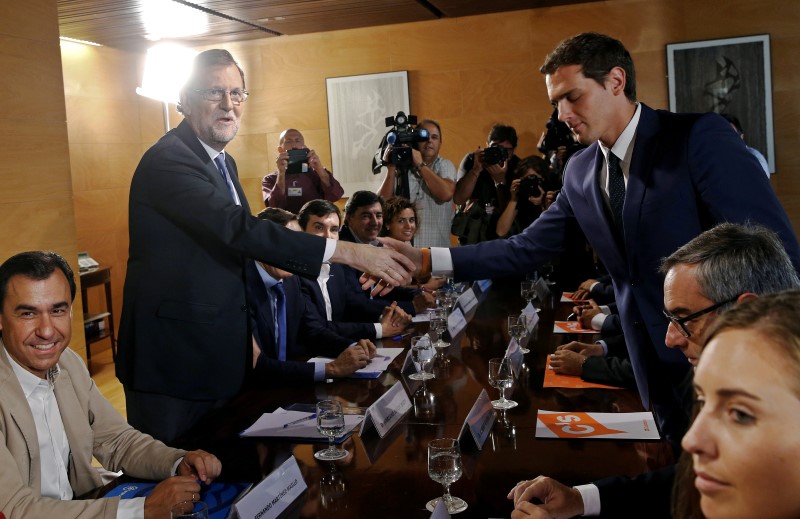 © Reuters. Spain's acting PM Rajoy and Ciudadanos leader Rivera shake hands during their meeting at the parliament in Madrid