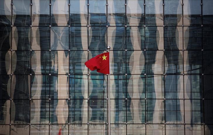 © Reuters. Chinese national flag flutters at the headquarters of a commercial bank on a financial street near the headquarters of the People's Bank of China, China's central bank, in central Beijing