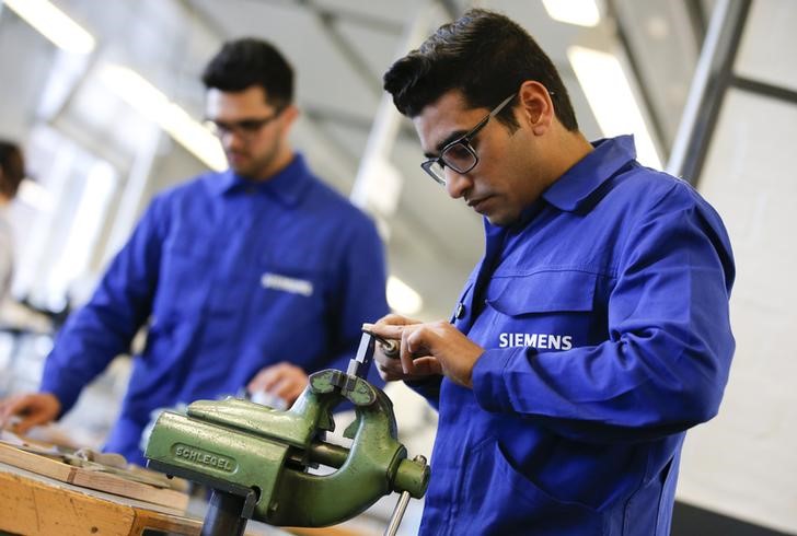 © Reuters. Refugees show their skills in metal processing works during a media tour at a workshop for refugees organized by German industrial group Siemens in Berlin